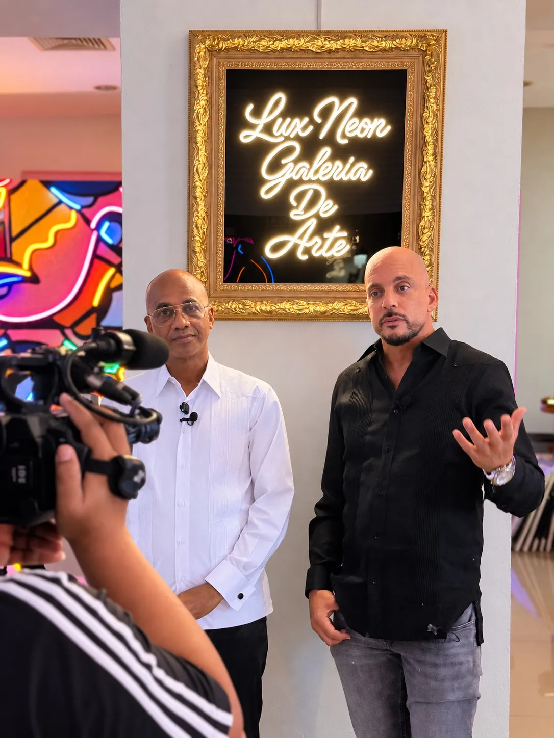 Una entrevista junto al letrero de la galería en Lux Neon, Zona Colonial