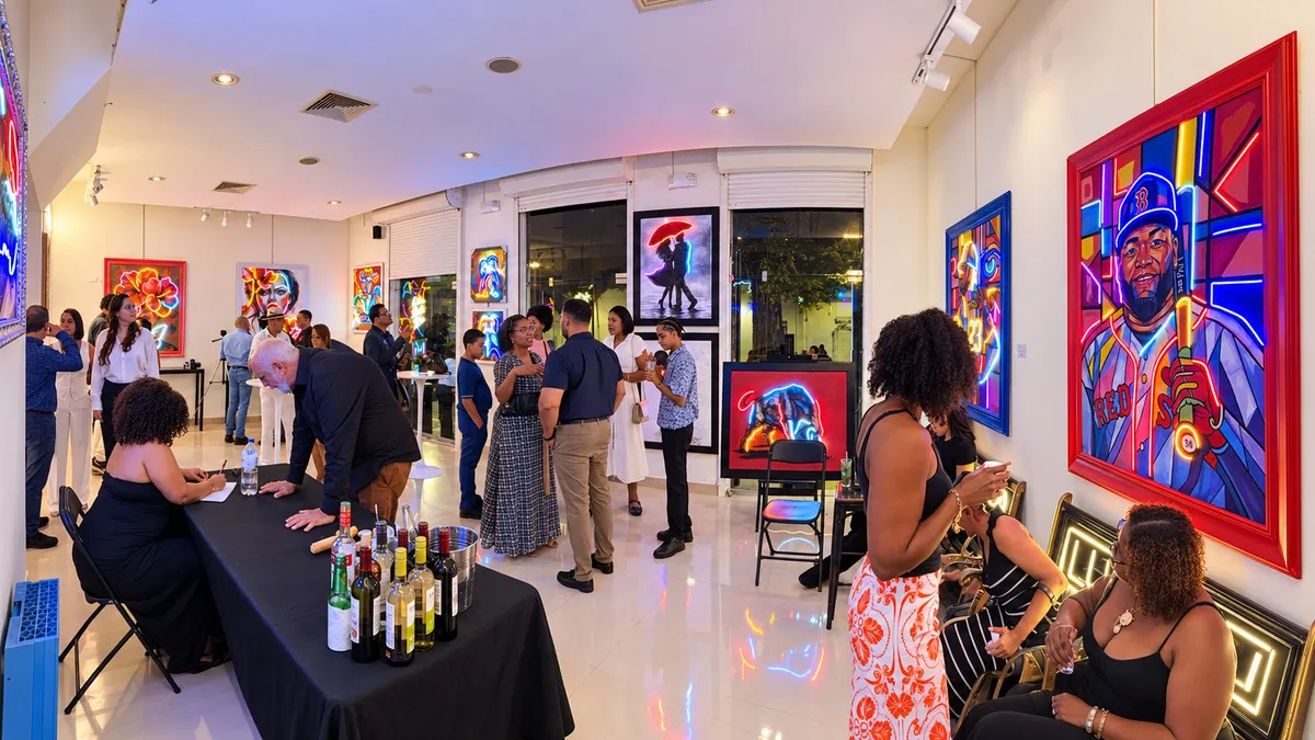 Invitados en una recepción en la galería Lux Neon, Zona Colonial, entre obras de arte iluminadas con neón